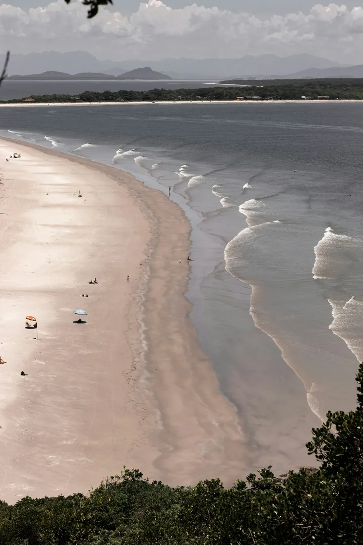 Faixa de areia e ondas da Ilha do Mel vistas do alto